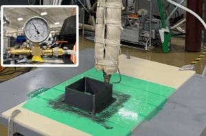 Vacuum-Assisted Extrusion 3D Printing nozzle extruding a dense composite polymer cube under vacuum to minimize internal voids